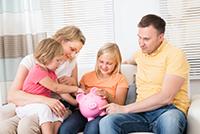 A family of four sits with a piggy bank