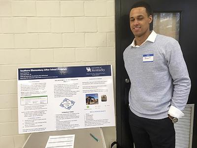 Internship Spotlight: Jason Fergerson stands beside a poster board presentation